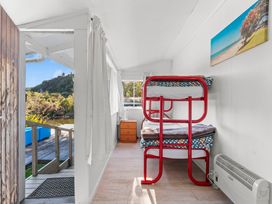 A bedroom with a bunk bed and nightstand at Kingfisher - Kuratau Holiday Home in Kuratau