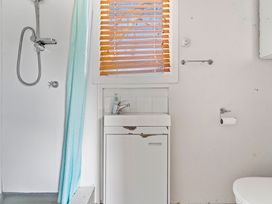 A bathroom with a shower and sink at Kingfisher - Kuratau Holiday Home, Kuratau