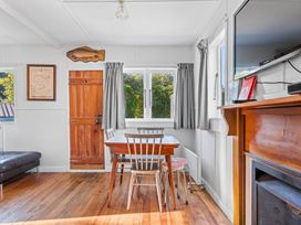 A living room with a table and chairs at Kingfisher - Kuratau Holiday Home in Kuratau