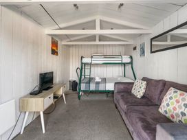A bedroom with bunk bed and television at Kingfisher - Kuratau Holiday Home, Kuratau