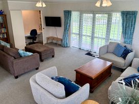 A living room with sofas and a coffee table at Waihi Getaway - Waihi Beach