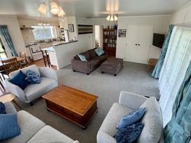 A living room with a sofa and dining area at Waihi Getaway - Waihi Beach