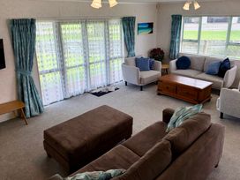 A living room with a sofa and armchairs at Waihi Getaway - Waihi Beach