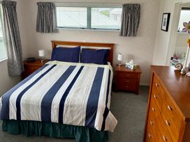 A bedroom with a bed and nightstands at Waihi Getaway - Waihi Beach