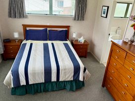 A bedroom with a bed and nightstands at Waihi Getaway - Waihi Beach
