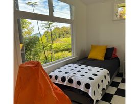 A bedroom with a bed and window at Hilltop Heaven - Kaiteriteri