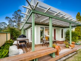 A house with a deck and table at Jacaranda Lodge - Napier Hill Holiday Home Bluff Hill