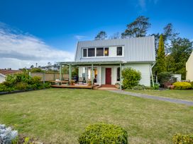 A house with a deck and garden at Jacaranda Lodge - Napier Hill Holiday Home Bluff Hill