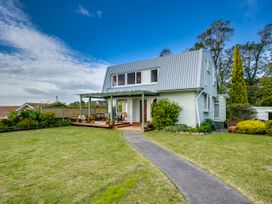 A house with a porch and garden at Jacaranda Lodge - Napier Hill Holiday Home, Bluff Hill