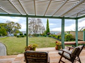 A garden with chairs and a pergola at Jacaranda Lodge - Napier Hill Holiday Home Bluff Hill