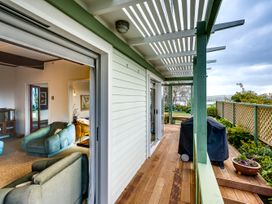 A deck area with grill and furniture at Jacaranda Lodge - Napier Hill Holiday Home in Bluff Hill
