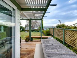 An outdoor deck with a wooden table and chairs at Jacaranda Lodge - Napier Hill Holiday Home Bluff Hill