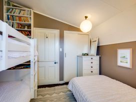 A bedroom with a bunk bed and bookshelf at Jacaranda Lodge - Napier Hill Holiday Home Bluff Hill