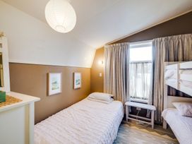 A bedroom with a bed and bunk bed at Jacaranda Lodge - Napier Hill Holiday Home in Bluff Hill