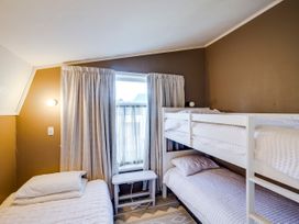 A bedroom with a bunk bed and a single bed at Jacaranda Lodge - Napier Hill Holiday Home, Bluff Hill
