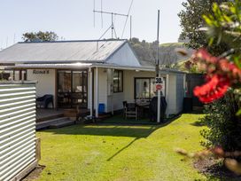 A house with a patio and garden at Ronas - Whiritoa Beach Bach Whiritoa Beach