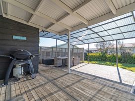 An outdoor area with a grill and dining set at Poppa's Place in Whangamata
