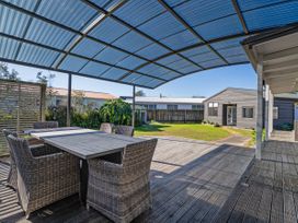 An outdoor area with a table and chairs at Fun at Whangamata - Whangamata
