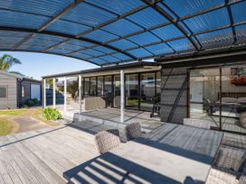 An outdoor patio with a table and chairs at Fun at Whangamata - Whangamata