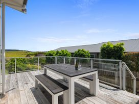 An outdoor deck with a table and chairs at Ruakaka Sands - Ruakaka