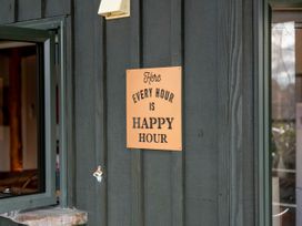 A sign that says every hour is happy hour at Treetop Hideaway - Taupo Holiday Home Taupo Central