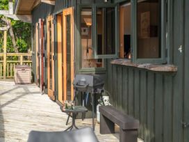 An outdoor area with a grill, tables, and chairs at Treetop Hideaway - Taupo Holiday Home, Taupo Central