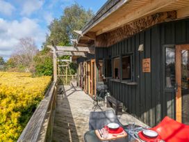 An outdoor deck with a table and chairs at Treetop Hideaway - Taupo Holiday Home Taupo Central