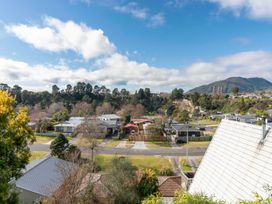 A view of houses and trees with mountains in the background at Treetop Hideaway - Taupo Holiday Home Taupo Central