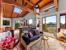 A living room with a sofa and dining area at Treetop Hideaway - Taupo Holiday Home Taupo Central