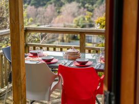 A dining table with chairs and tableware at Treetop Hideaway - Taupo Central