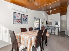 A dining room with a table and chairs at Sunnyside Spa Retreat - Mangawhai Heads