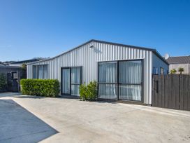 A house with windows and door surrounded by bushes at Sunnyside Spa Retreat - Mangawhai Holiday Home Mangawhai Heads