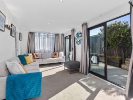 A living room with a sofa and coffee table at Sunnyside Spa Retreat - Mangawhai Heads