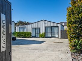 An outdoor area with a building and signage at Sunnyside Spa Retreat - Mangawhai Heads