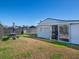 An outdoor area with a picnic table and umbrella at Sunnyside Spa Retreat - Mangawhai Heads