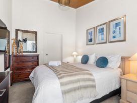 A bedroom with a bed and a dresser at Sunnyside Spa Retreat - Mangawhai Holiday Home Mangawhai Heads