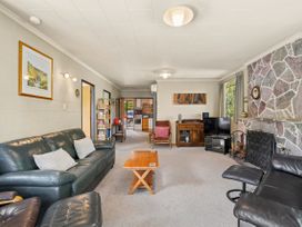 A living room with a sofa, coffee table, and television at Lakeside Serenity - Wanaka