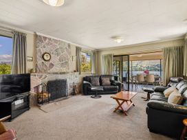 A living room with sofas and a television at Lakeside Serenity - Wanaka Holiday Home Wanaka