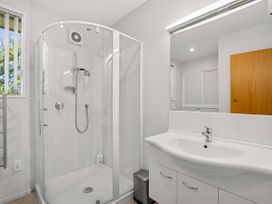A bathroom with a shower, sink, and mirror at Lakeside Serenity - Wanaka Holiday Home, Wanaka
