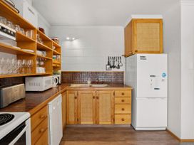 A kitchen with microwave and refrigerator at Lakeside Serenity - Wanaka Holiday Home in Wanaka