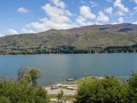 A view of a lake surrounded by mountains and trees at Lakeside Serenity - Wanaka Holiday Home Wanaka