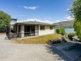 An exterior view of a house with a patio and gravel driveway at Lakeside Serenity - Wanaka Holiday Home Wanaka