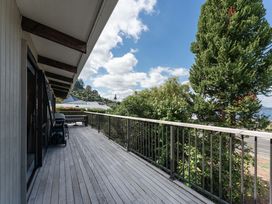 An outdoor deck with railing and trees at Acacia View at No. 3 - Acacia Bay