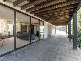 An outdoor patio with a sofa and glass wall at Acacia View at No. 3 - Acacia Bay