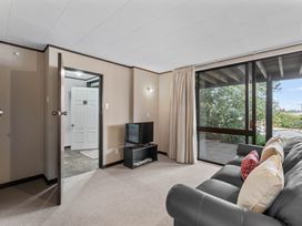 A living room with a television and a view of the outdoors at Acacia View at No. 3 - Acacia Bay