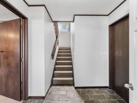 A hallway with a staircase and doors at Acacia View at No. 3 - Acacia Bay