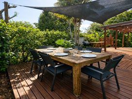 An outdoor dining table with chairs and plants at Matapouri Hideaway in Matapouri