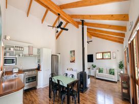A kitchen and living area with dining table and sofa at Matapouri Hideaway - Matapouri