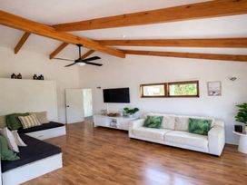 A living room with a ceiling fan and television at Matapouri Hideaway - Matapouri