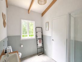 A bathroom with bathtub, toilet, and hand towel rack at Matapouri Hideaway - Matapouri